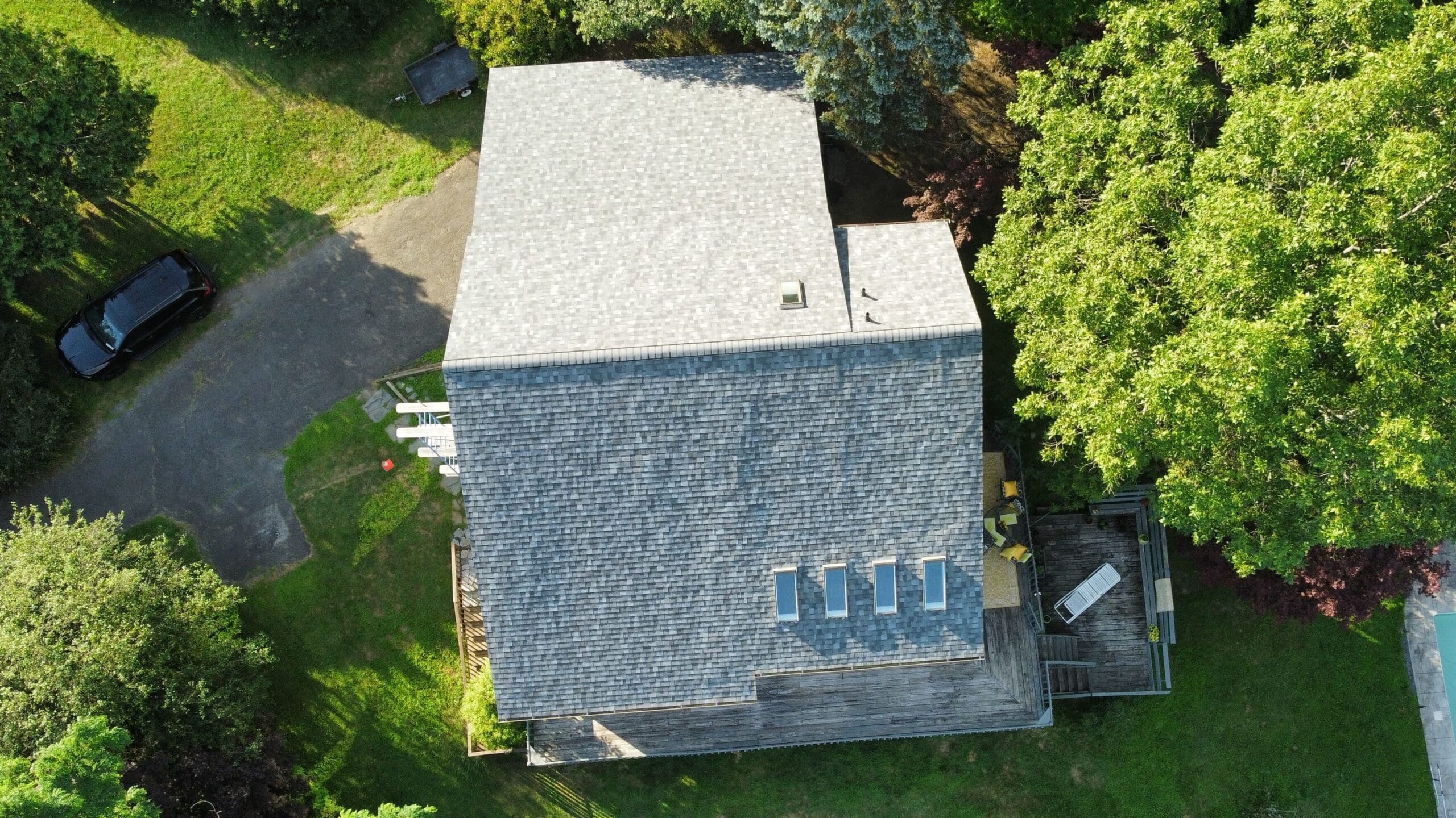 Aerial view of replaced roof with Owens Corning Slatestone Gray asphalt shingles with skylights that were reflashed and resealed