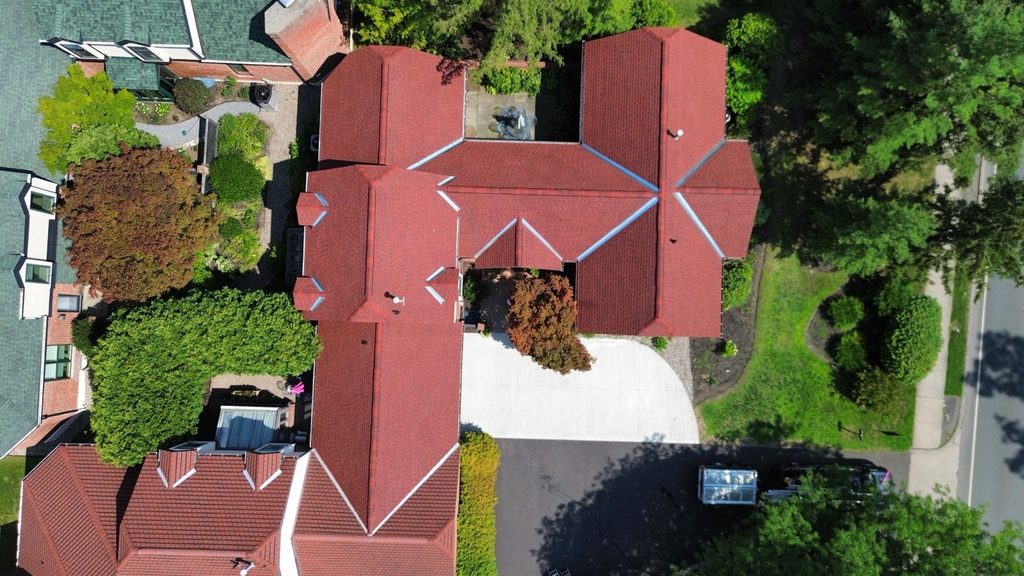 Building with roof replacement completed by KC Entities Roofing and Siding with GAF Patriot Red asphalt shingles